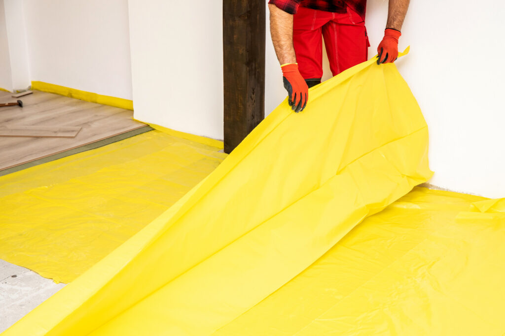 Male worker installing new wooden laminate flooring. 